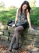 Hot MILF brunette is posing outdoors in her silky black pantyhose and tall shiny heels